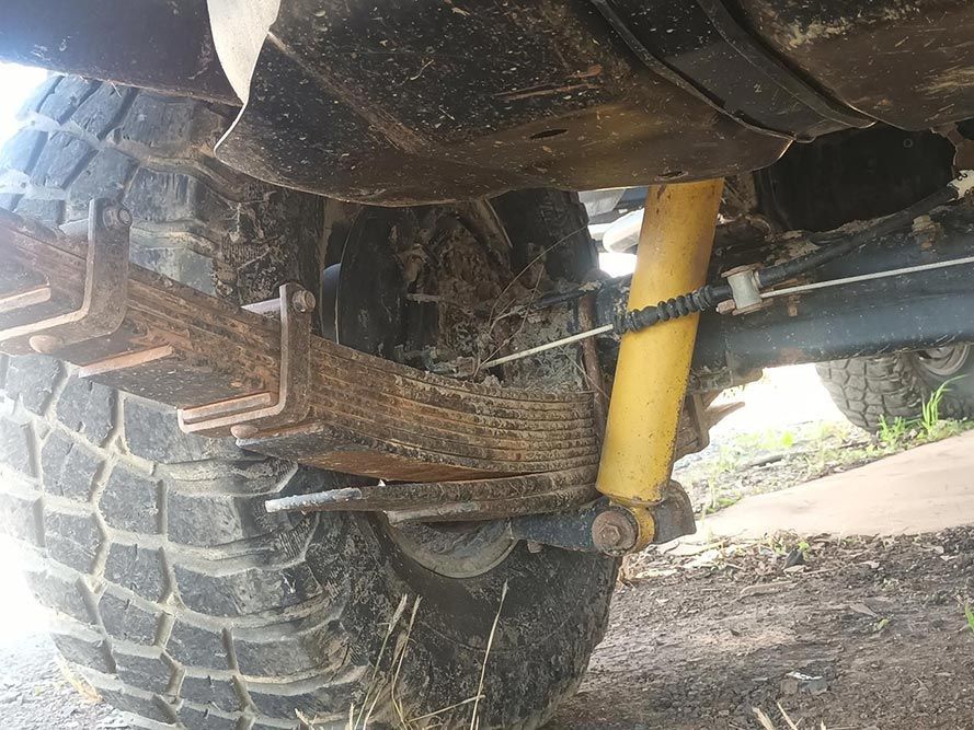 A Yellow Shock Absorber is Attached to the Underside of a Vehicle — South West 4WD Wreckers in Harristown, QLD