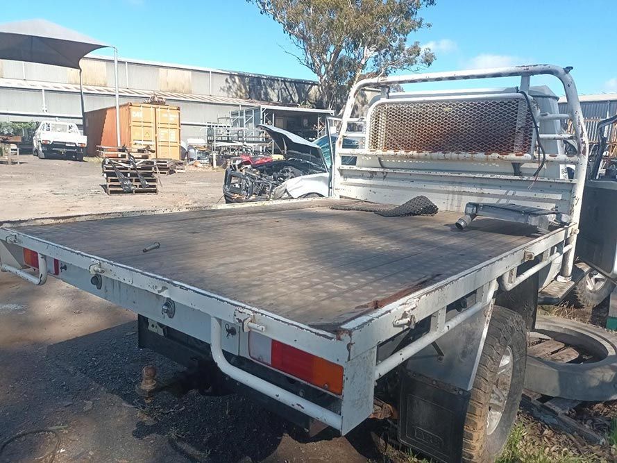 A Truck with a Flat Bed is Parked in a Lot