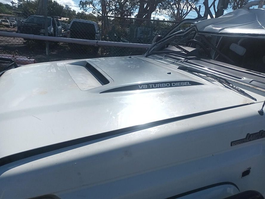 The Hood of a White Truck is Sitting in a Parking Lot — South West 4WD Wreckers in Harristown, QLD
