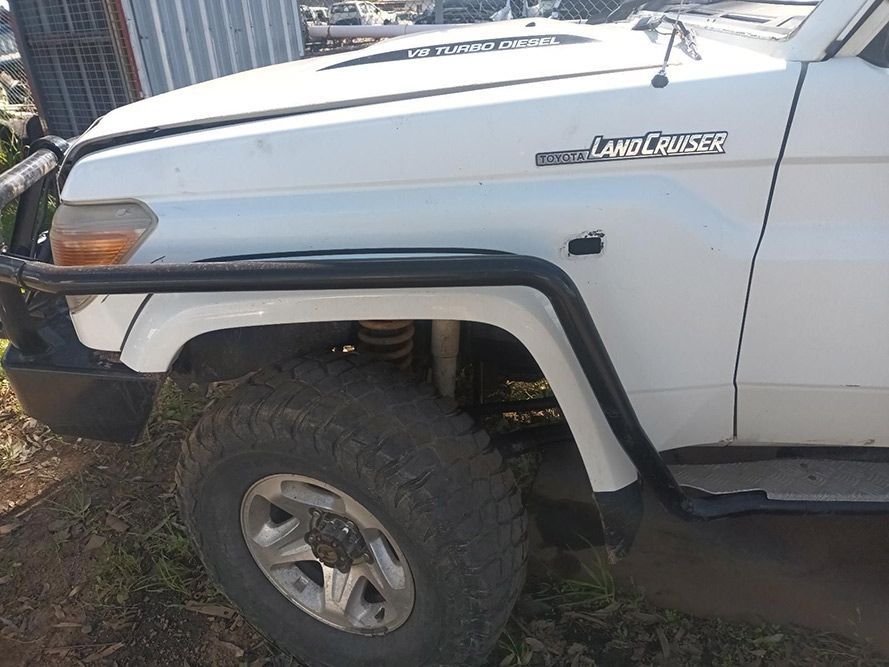 A White Toyota Land Cruiser is Parked on the Side of the Road — South West 4WD Wreckers in Harristown, QLD