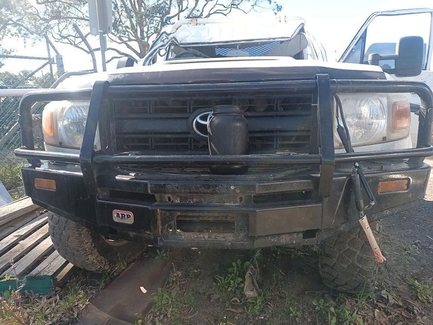 A Toyota Land Cruiser with a Bumper Protector is Parked in the Grass — South West 4WD Wreckers in Harristown, QLD