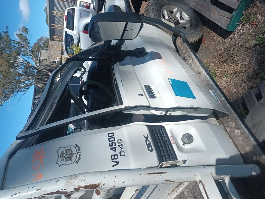 A White Truck with the Door Open is Parked on the Side of the Road — South West 4WD Wreckers in Harristown, QLD