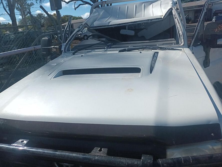 A White Truck with a Broken Windshield is Parked on the Side of the Road — South West 4WD Wreckers in Harristown, QLD
