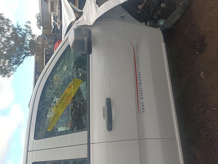 A White Van with a Yellow Sticker on the Door is Sitting on the Ground — South West 4WD Wreckers in Harristown, QLD