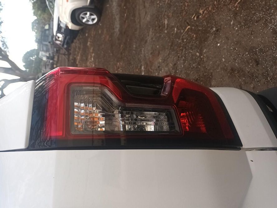 A White Truck with a Red Tail Light is Parked in a Dirt Lot — South West 4WD Wreckers in Harristown, QLD