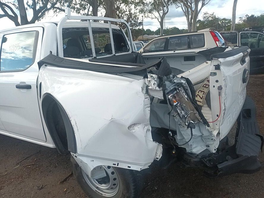 A White Truck with a Damaged Back End is Parked in a Parking Lot — South West 4WD Wreckers in Harristown, QLD