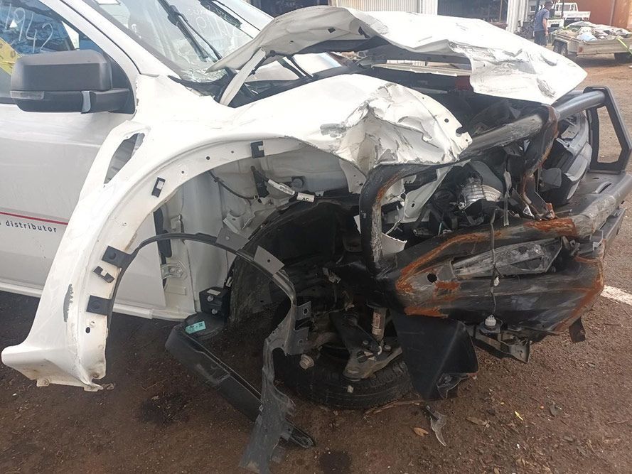 A White Car with a Damaged Front End is Parked on the Side of the Road — South West 4WD Wreckers in Harristown, QLD