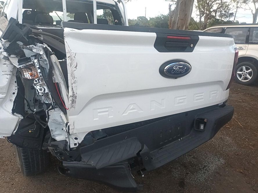 The Back End of a White Ford Ranger Truck is Damaged — South West 4WD Wreckers in Harristown, QLD