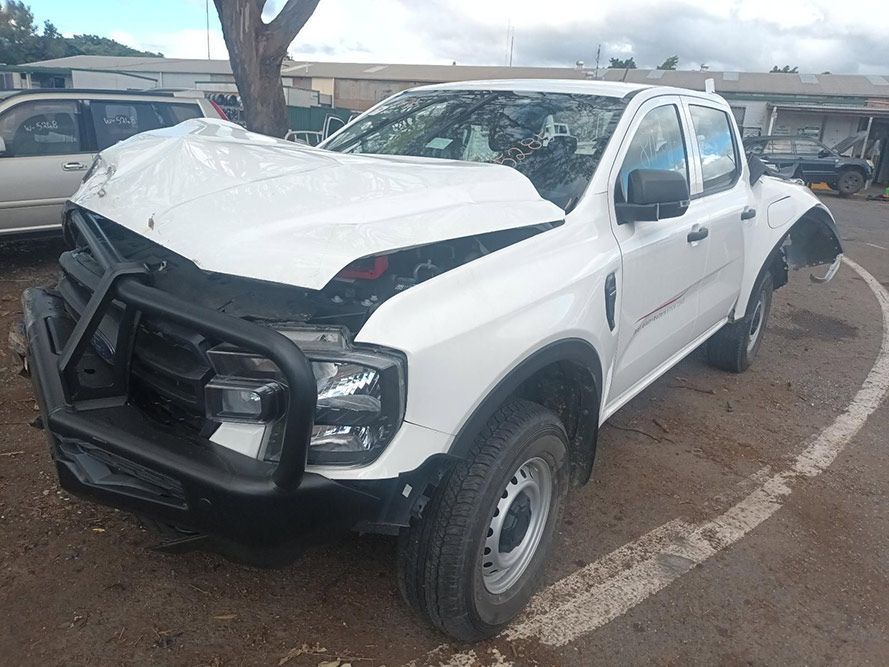 A White Truck with a Damaged Hood is Parked in a Parking Lot — South West 4WD Wreckers in Harristown, QLD