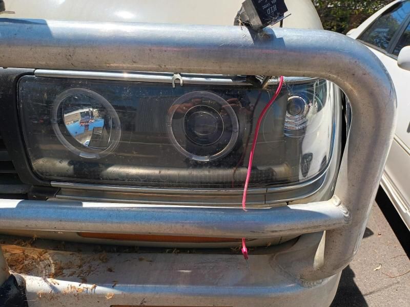 A Close Up of a Cars Headlight With a Red Wire Attached to It — South West 4WD Wreckers In Brisbane, QLD