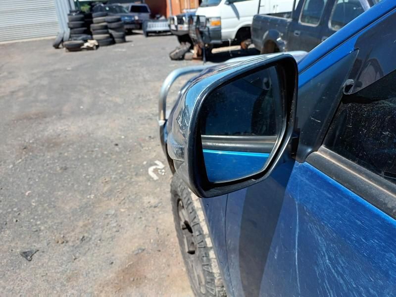A Blue Car is Parked in a Parking Lot With Tires in the Background — South West 4WD Wreckers In Brisbane, QLD