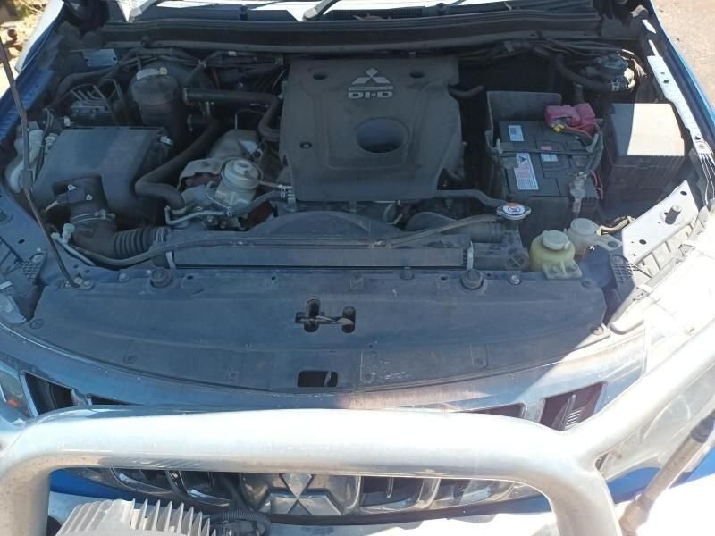 The Engine of a Blue Mitsubishi Truck is Visible Under the Hood — South West 4WD Wreckers In Brisbane, QLD