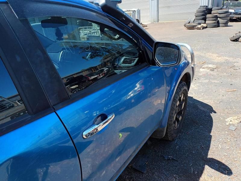 A Blue Car is Parked in a Parking Lot Next to a Pile of Tires — South West 4WD Wreckers In Brisbane, QLD