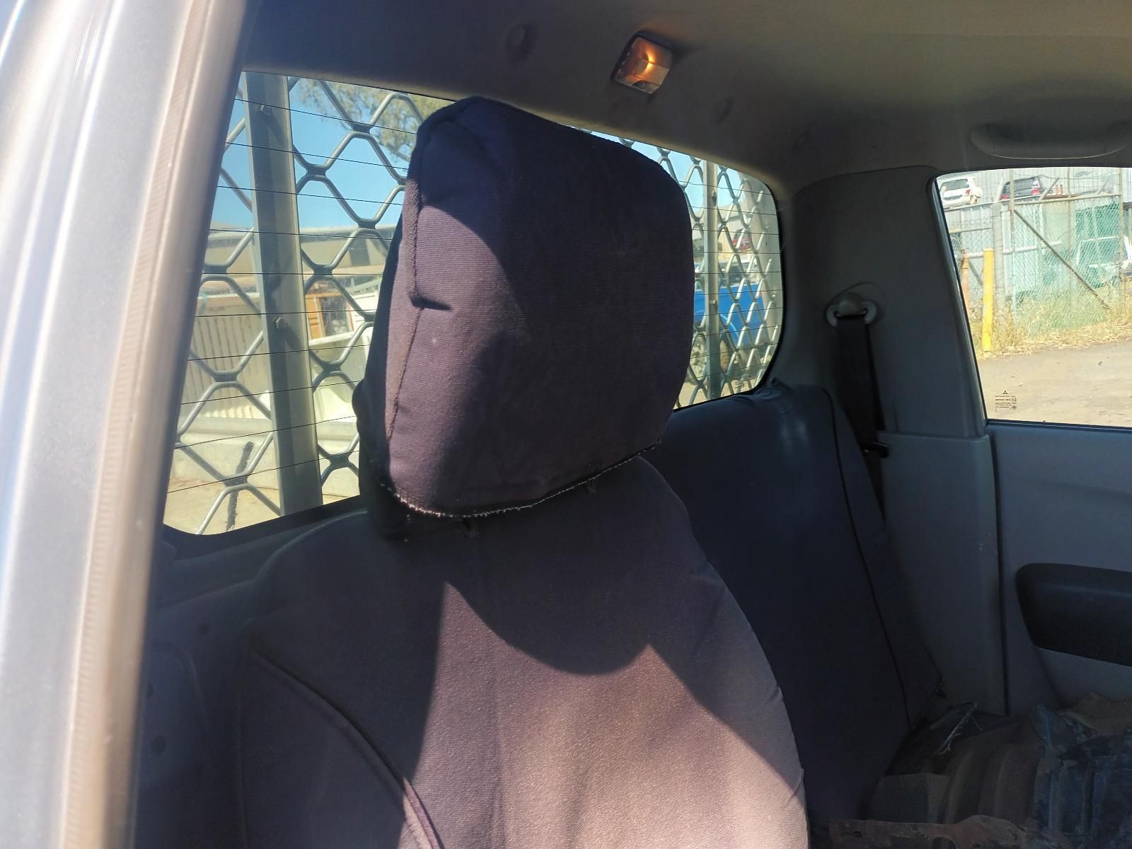 A Person Wearing a Mask is Sitting in the Back Seat of a Car — South West 4WD Wreckers In Brisbane, QLD