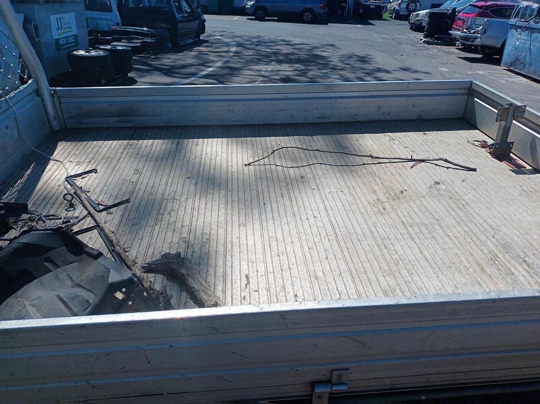 An Empty Truck Bed is Sitting in a Parking Lot — South West 4WD Wreckers In Brisbane, QLD