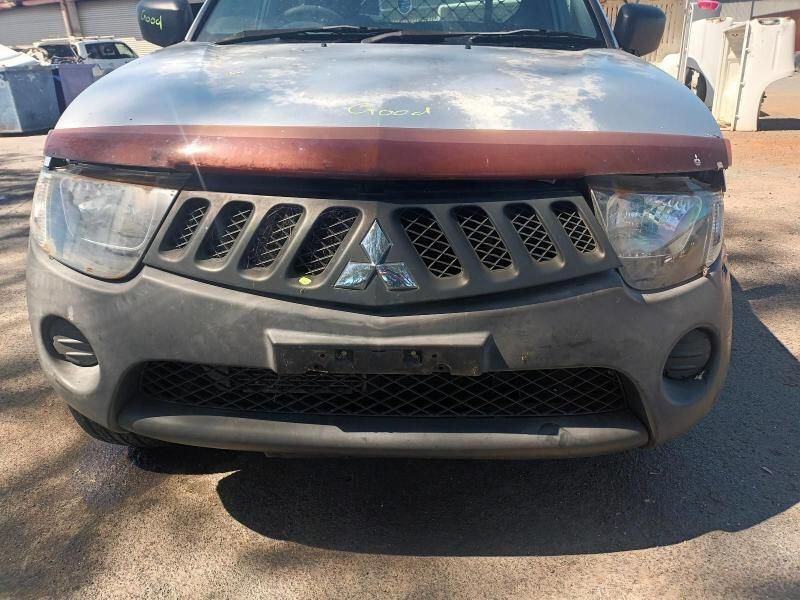 A Silver Truck With a Red Hood is Parked on the Side of the Road — South West 4WD Wreckers In Brisbane, QLD