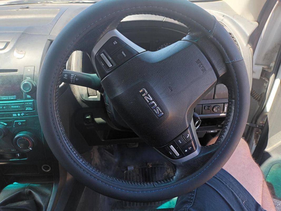 A Person is Holding a Black Steering Wheel in a Car — South West 4WD Wreckers In Brisbane, QLD