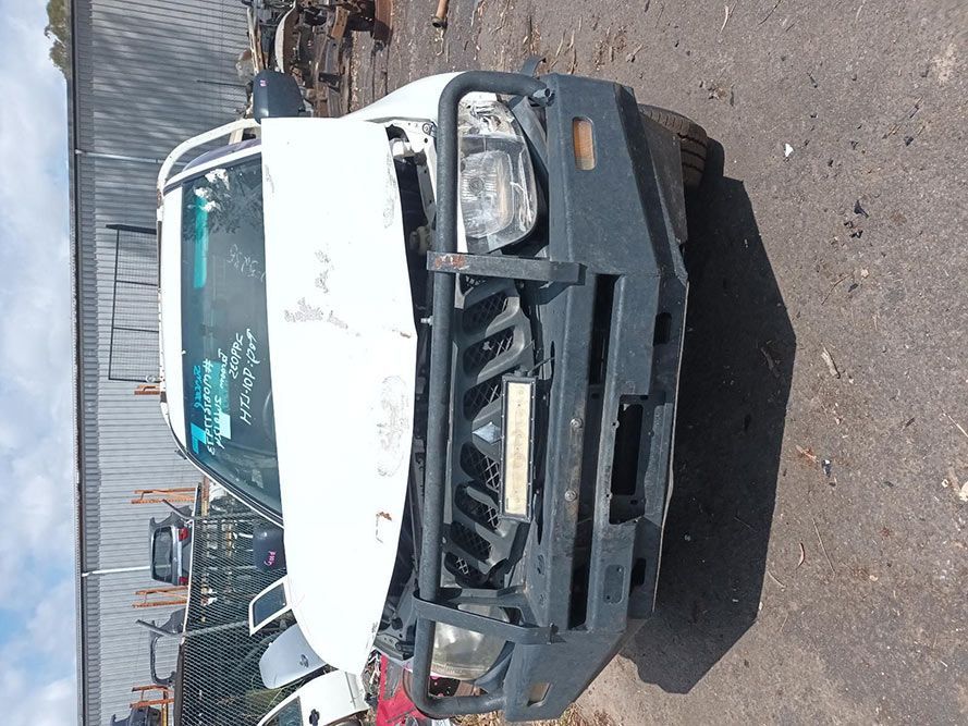 A White Truck With a Black Bumper is Parked on the Side of the Road — South West 4WD Wreckers In Brisbane, QLD