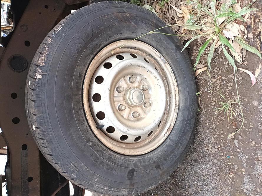 A Tire is Sitting on the Ground Next to a Metal Rim — South West 4WD Wreckers In Brisbane, QLD