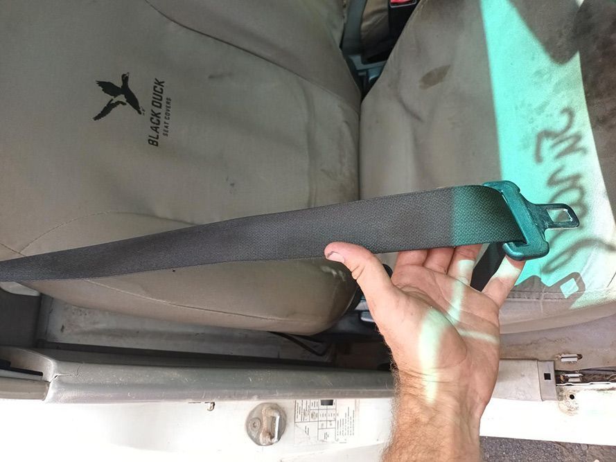 A Person is Holding a Seat Belt in a Car — South West 4WD Wreckers In Brisbane, QLD