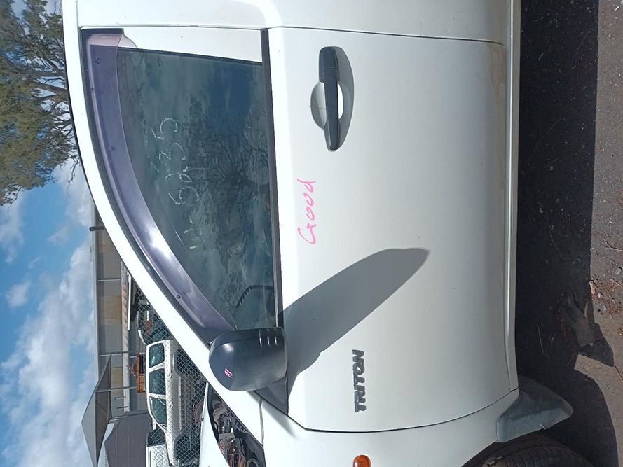 A White Triton Truck is Parked on the Side of the Road — South West 4WD Wreckers In Brisbane, QLD