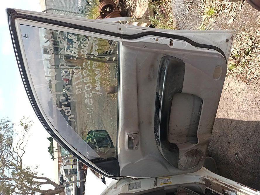 A White Car With the Door Open and a Reflection of Trees in the Window — South West 4WD Wreckers In Brisbane, QLD