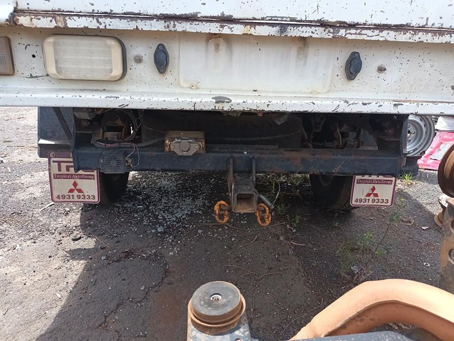 A Mitsubishi Truck is Parked on the Side of the Road — South West 4WD Wreckers In Brisbane, QLD