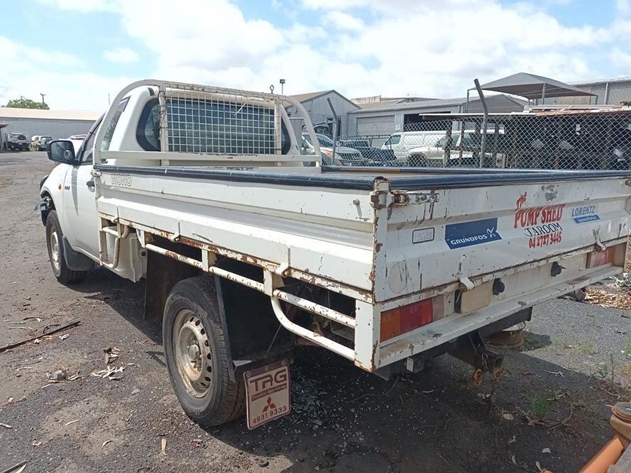 A White Truck With a Flat Bed is Parked in a Parking Lot — South West 4WD Wreckers In Brisbane, QLD