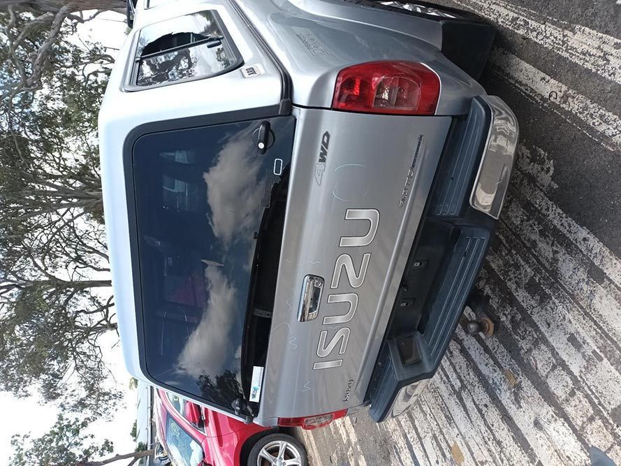 A Silver Isuzu Truck is Parked in a Parking Lot — South West 4WD Wreckers In Harristown, QLD