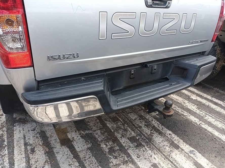 A Silver Isuzu Truck is Parked on the Side of the Road — South West 4WD Wreckers In Harristown, QLD