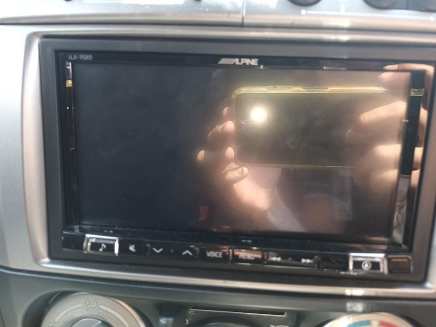 A Person is Holding a Phone in Front of a Alpine Car Stereo — South West 4WD Wreckers In Harristown, QLD
