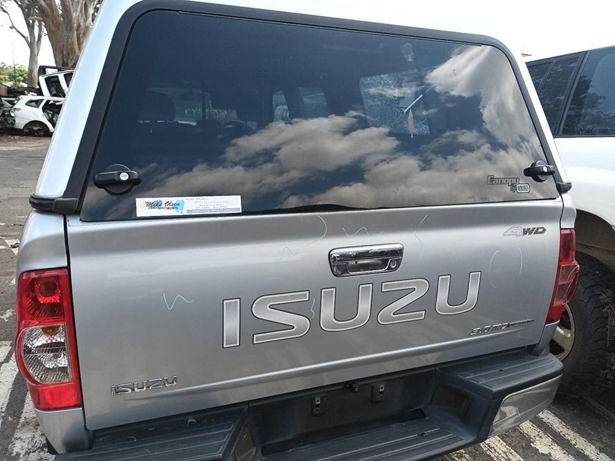 A Silver Isuzu Truck is Parked in a Parking Lot — South West 4WD Wreckers In Harristown, QLD