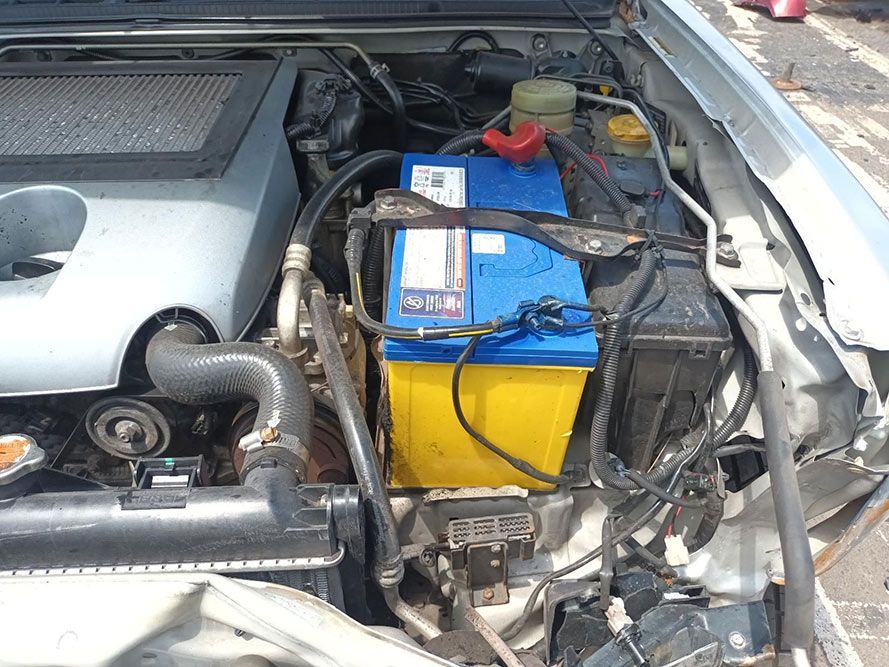 A Blue and Yellow Battery is Sitting Under the Hood of a Car — South West 4WD Wreckers In Harristown, QLD