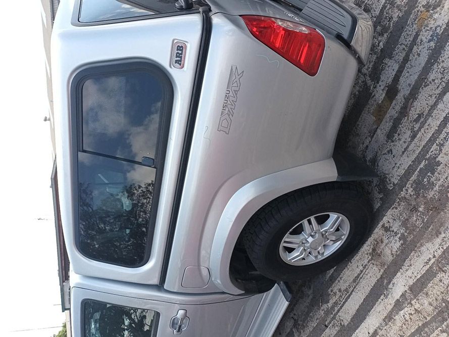 A Silver Truck With a Canopy is Parked on the Side of the Road — South West 4WD Wreckers In Harristown, QLD