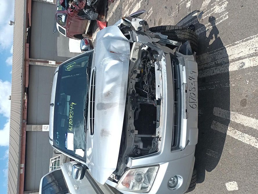 A Silver Car With a Damaged Front End is Parked on the Side of the Road — South West 4WD Wreckers In Harristown, QLD