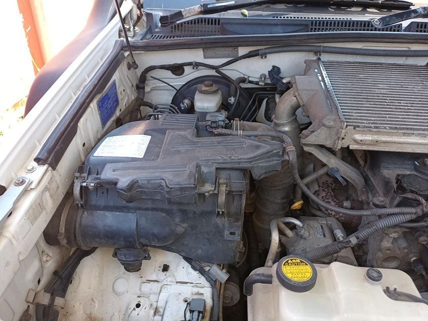 The Engine of a White Car is Shown With the Hood Open — South West 4WD Wreckers In Brisbane, QLD