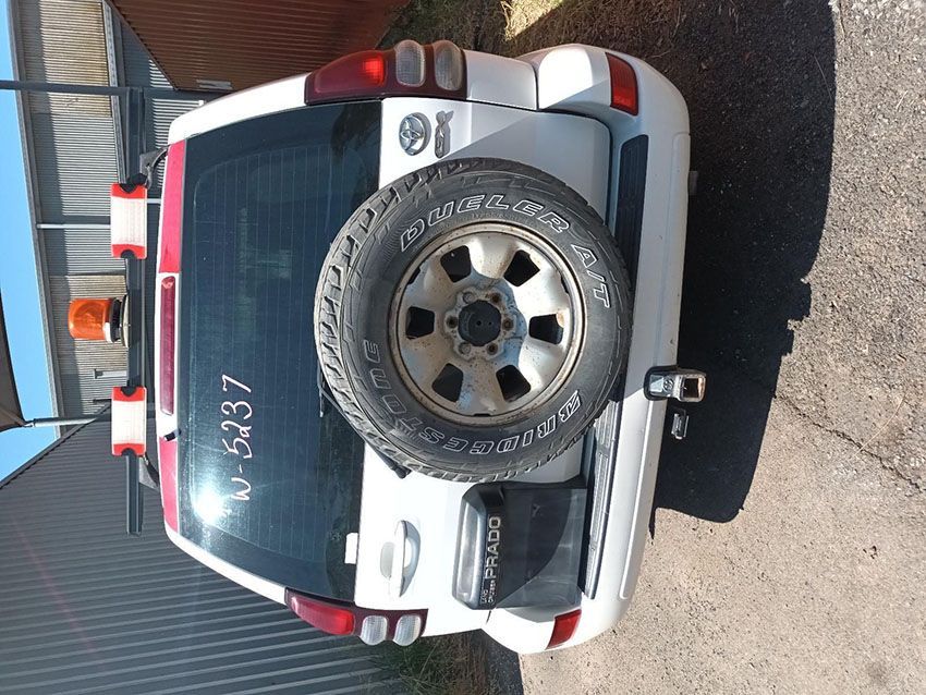 A White SUV With a Spare Tire is Parked on the Side of the Road — South West 4WD Wreckers In Brisbane, QLD