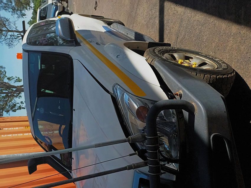 A White Truck With a Yellow Stripe is Parked on the Side of the Road — South West 4WD Wreckers In Brisbane, QLD