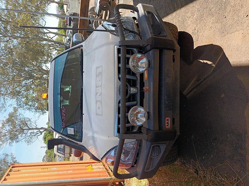A White Truck is Parked Next to a Large Orange Container — South West 4WD Wreckers In Brisbane, QLD