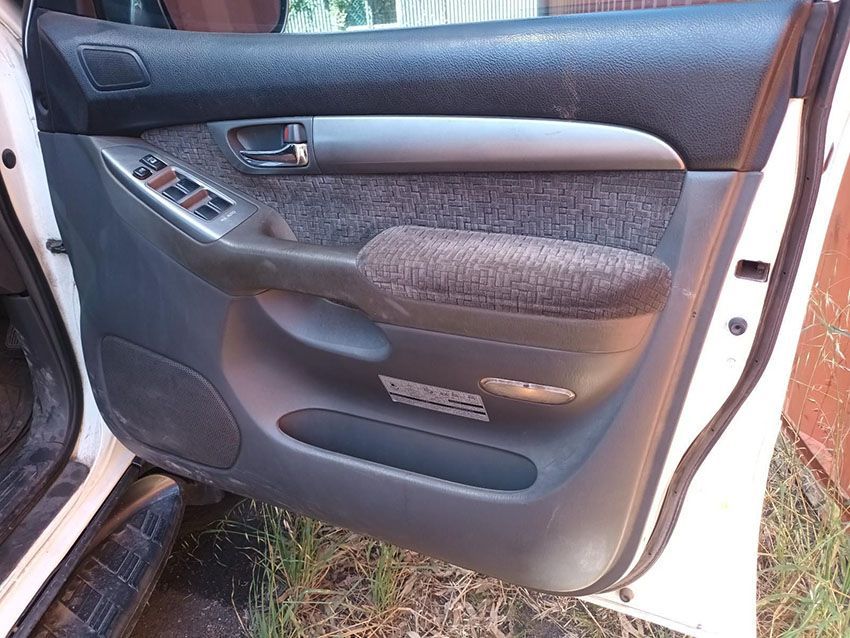 The Door of a White Car is Open and Sitting in the Grass — South West 4WD Wreckers In Brisbane, QLD