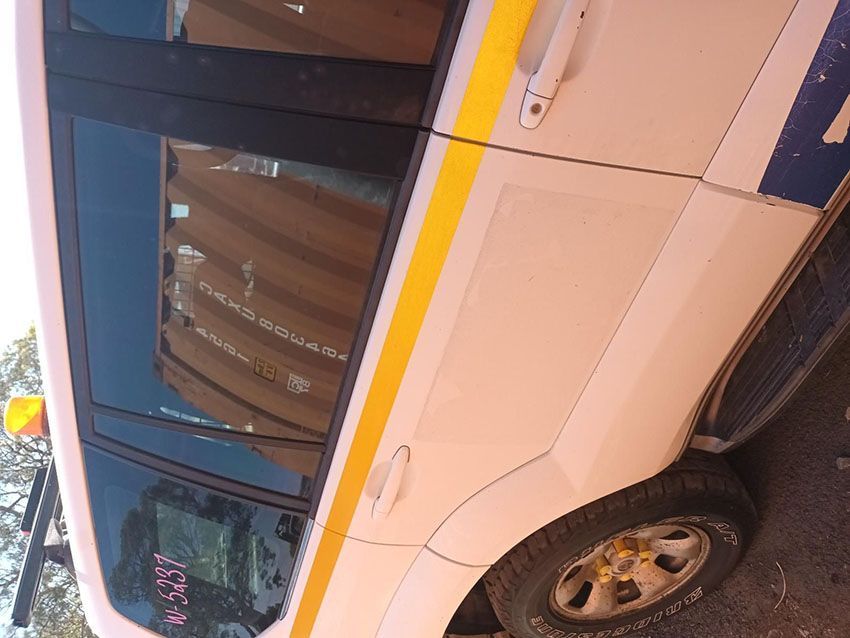 A White Van With a Yellow Stripe on the Door is Parked on the Side of the Road — South West 4WD Wreckers In Brisbane, QLD