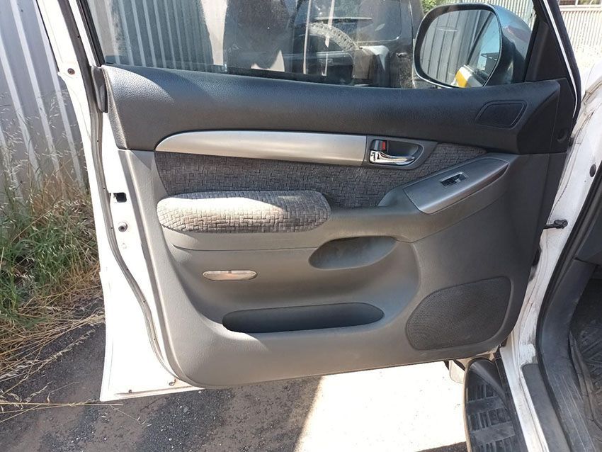 A White Car With the Door Open is Parked in Front of a Fence — South West 4WD Wreckers In Brisbane, QLD