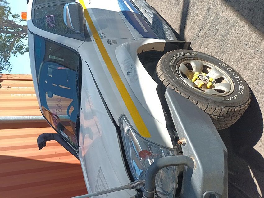 A White Car With a Yellow Stripe on the Side is Parked on the Side of the Road — South West 4WD Wreckers In Brisbane, QLD