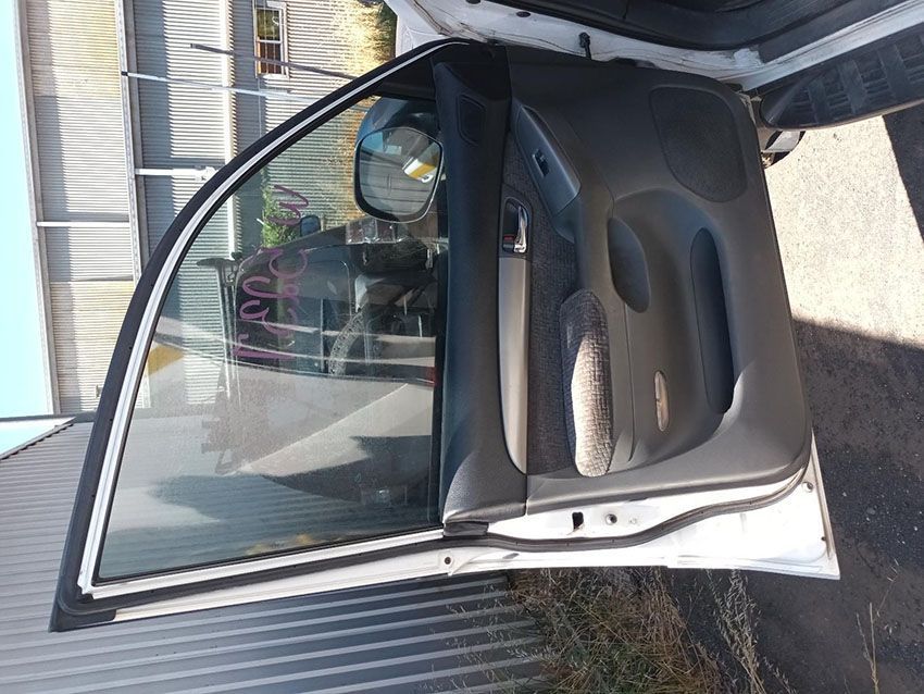 A White Car With the Door Open is Parked on the Side of the Road — South West 4WD Wreckers In Brisbane, QLD