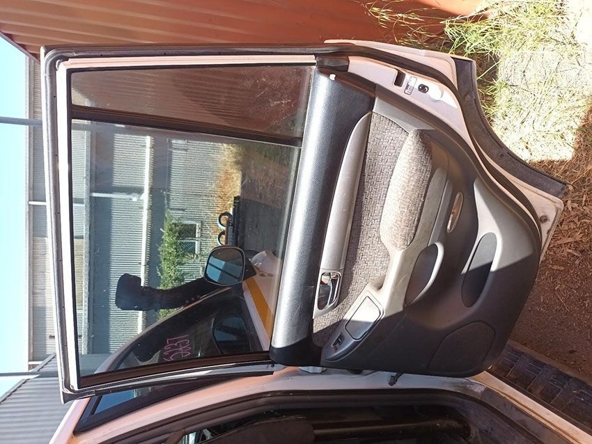 A Car With the Door Open is Parked Next to a Fence — South West 4WD Wreckers In Brisbane, QLD