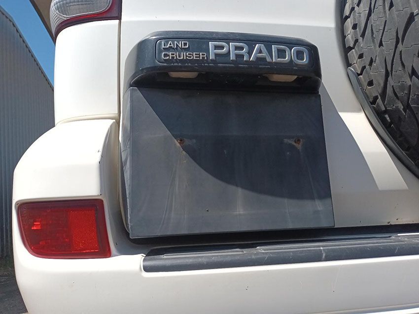 A White Land Cruiser Prado is Parked in Front of a Building — South West 4WD Wreckers In Brisbane, QLD