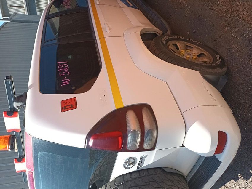 A White Toyota Land Cruiser is Parked on the Side of the Road — South West 4WD Wreckers In Brisbane, QLD