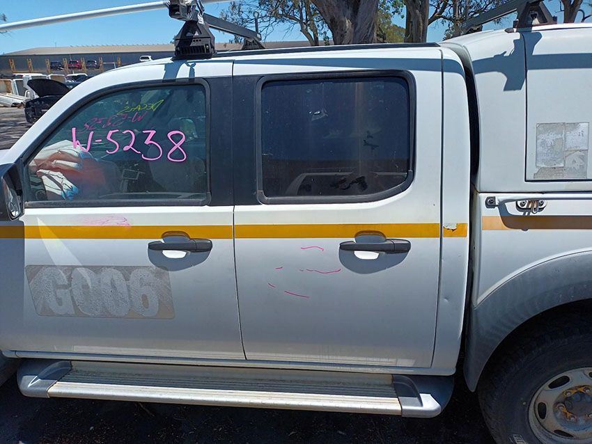 A Silver Truck With a Yellow Stripe on the Side is Parked in a Parking Lot — South West 4WD Wreckers In Brisbane, QLD