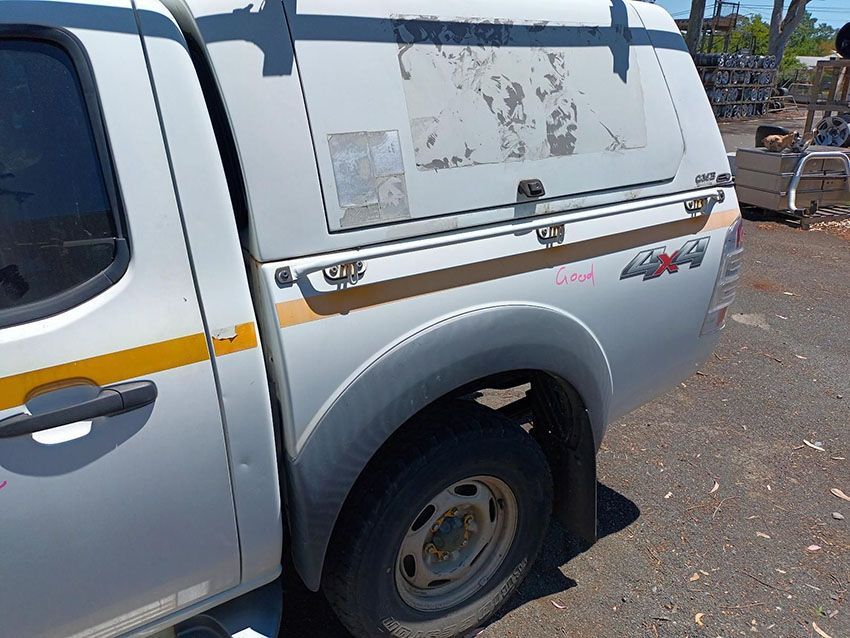 A White Truck With a Canopy on the Back is Parked on the Side of the Road — South West 4WD Wreckers In Brisbane, QLD