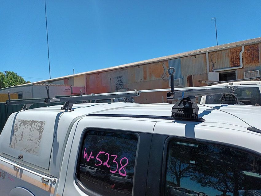 A White Truck With a Roof Rack on It is Parked in Front of a Building — South West 4WD Wreckers In Brisbane, QLD